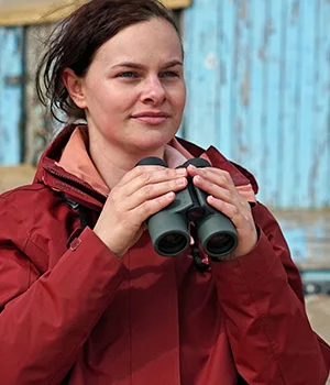 Woman looking through Kowa binoculars