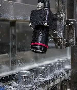 Kowa lens inspecting cans on a wet production line